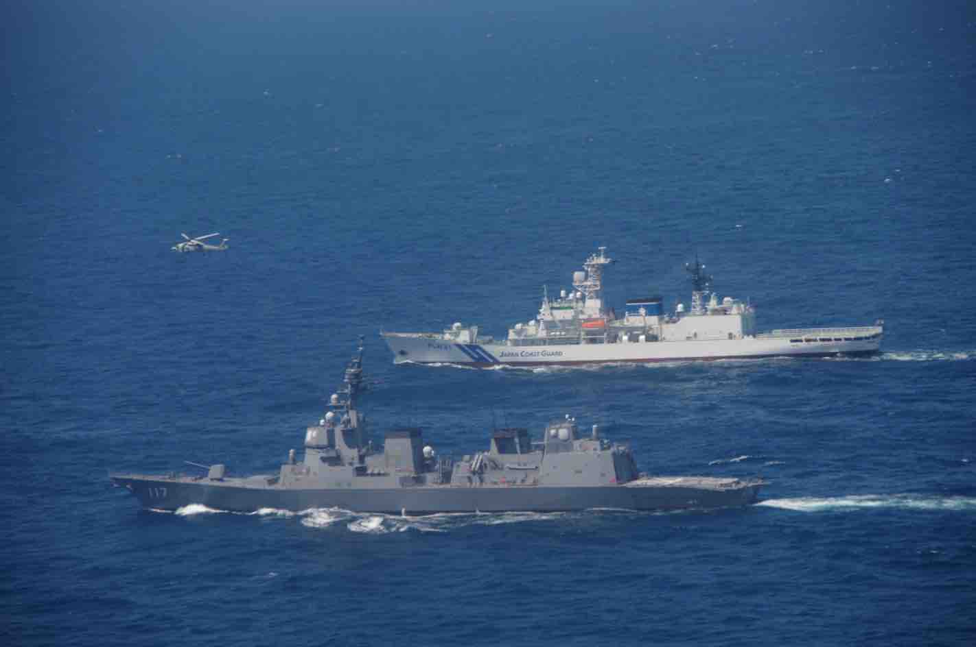 Japanese coast guard vessel alongside a Japanese naval warship